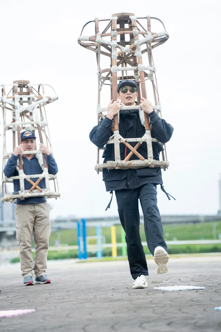 范逸臣（左）、曹佑寧扛起竹架子，認真練習。民視提供