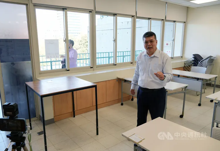 台大教務處註冊組長李宏森（右）在特殊試場展示各式設備，包含為輪椅族特製的增高桌等。中央社