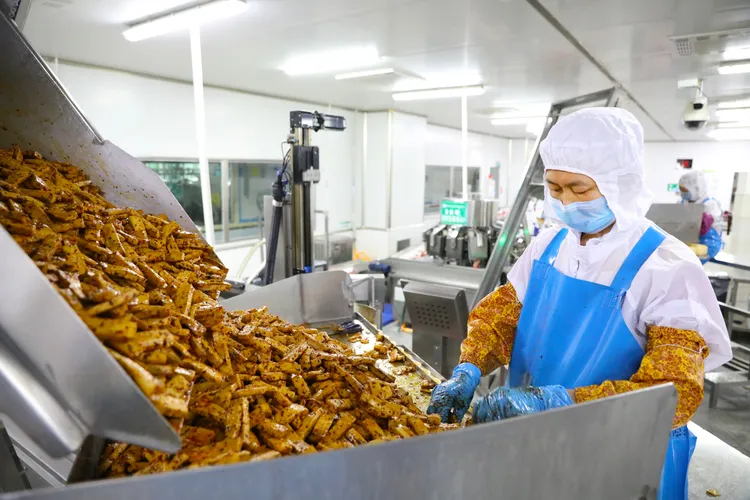 重慶梁平區一家豆製品企業，昨天工人在生產線上忙碌。新華社