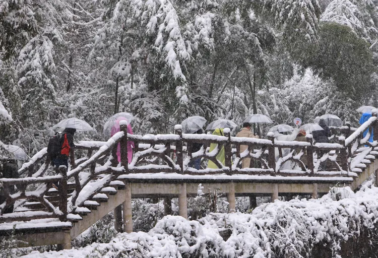 遊人22日在湖南省張家界市武陵源寶峰湖景區賞雪遊玩。新華社