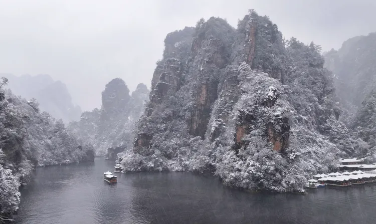 遊人乘船22日在湖南省張家界市武陵源寶峰湖景區賞雪遊玩。新華社