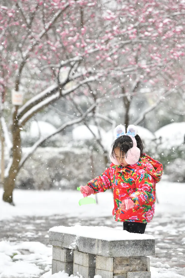 1名小朋友22日在貴州省黔東南苗族侗族自治州黃平縣行政中心廣場玩雪。新華社