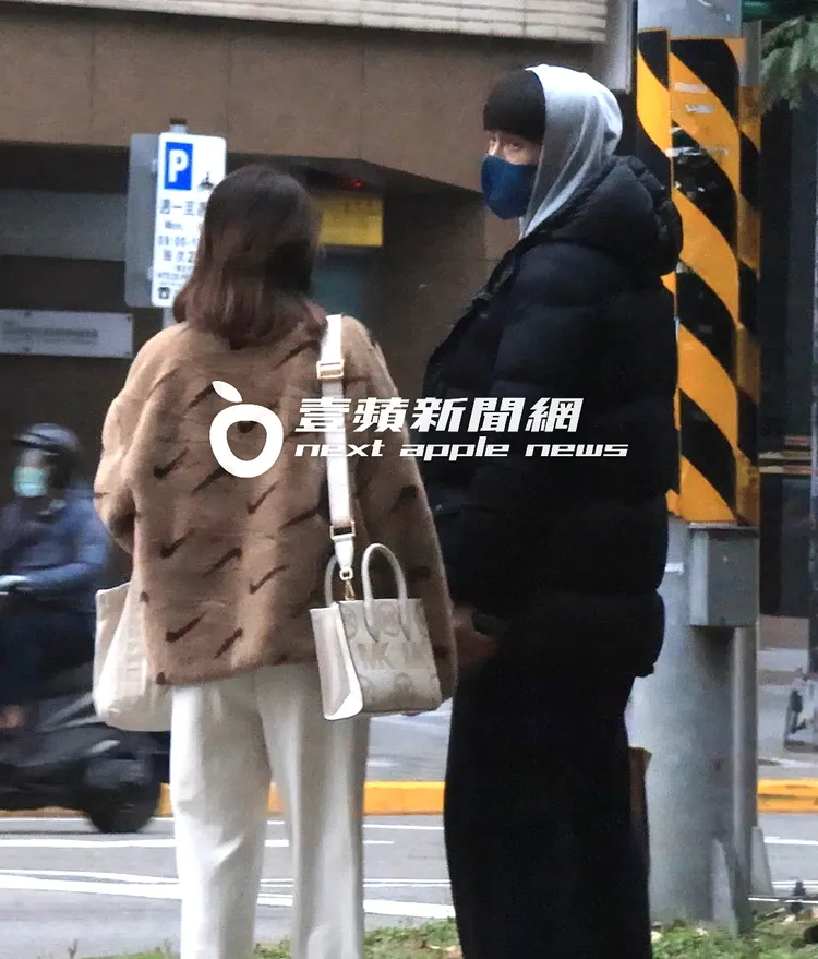 Gino（右）和穿著3000多元NIKE絨毛外套，及肩背價值1萬多元MK包包的「纖細妹」，並肩等過馬路。特勤中心攝