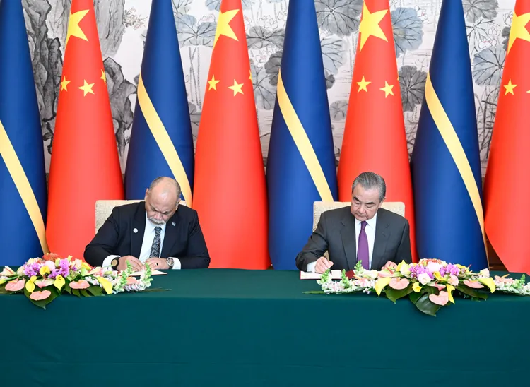 中國外交部長王毅（右），今在在北京與諾魯外長安格明簽署復交公報。新華社