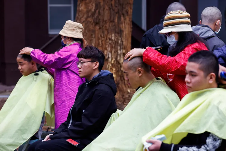 現場有理髮人員為役男剃髮。路透社