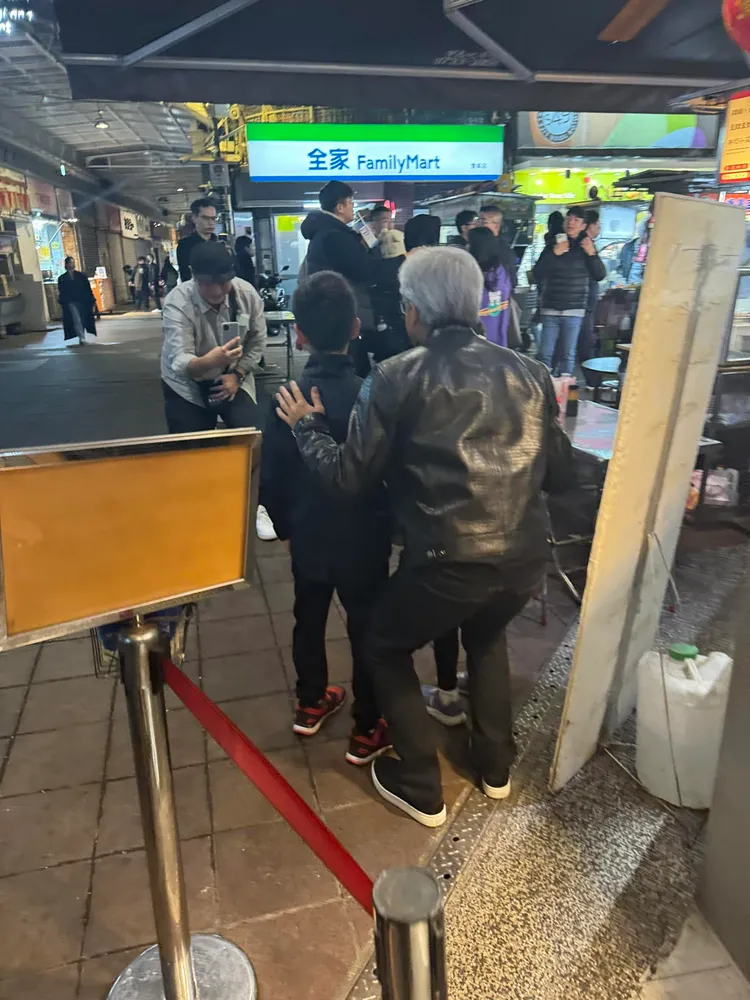 黃仁勳與孩童拍照屈膝蹲低，親和力十足。翻攝阿萬鵝肉