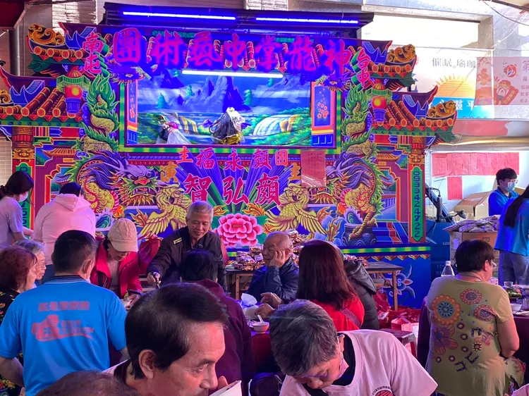 全成基金會辦理寒冬送暖歲末圍爐活動，民眾邊吃辦桌邊看布袋戲。民眾提供