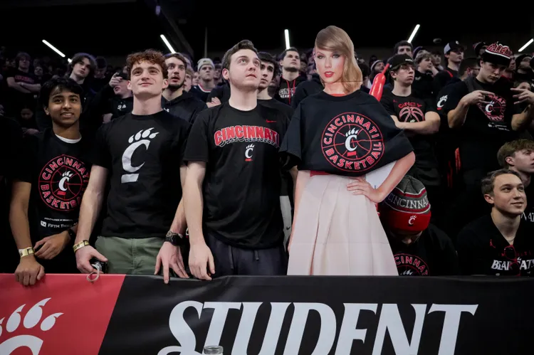 本月一場美國大學的美式足球比賽，學生在用泰勒絲的看板旁觀賽。路透社