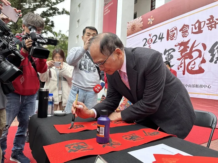 立法院中部辦公室27日舉辦新春揮毫活動，立法院長游錫堃（右）開筆寫下「開放國會齊守護 自由民主萬年行」。中央社