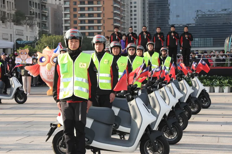 領唱國歌的清潔隊員騎乘電動機車帥氣登場。市府提供