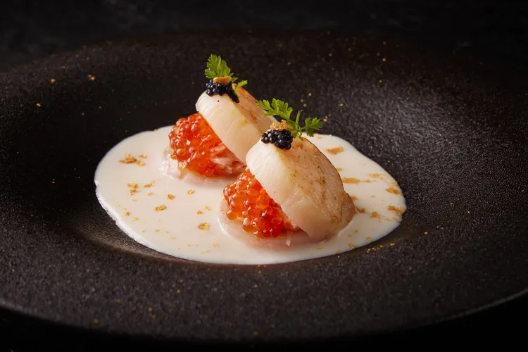 即日起至2月底，到「王品牛排」品嚐1790元及1990元的「盛宴套餐」各一客並出示優惠活動畫面，就款待「嫩煎干貝佐鱒魚卵松葉蟹」。業者提供