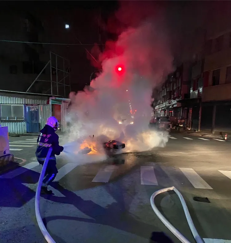機車倒地起火，警消到場灌救。讀者提供