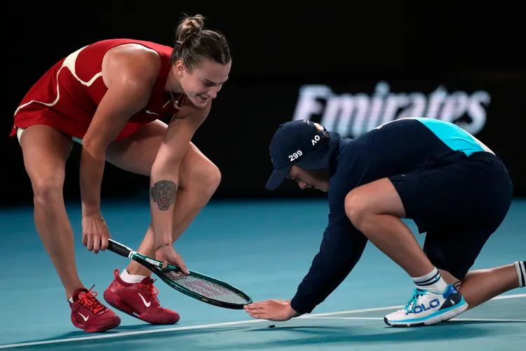 莎芭蓮卡（左）與球僮聯手拯救場上一隻昆蟲。美聯社