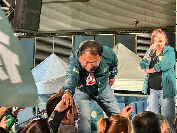 現場支持者不肯散去，還變成謝志工的小型造勢。圖為謝志忠在台上與台下直持者握手。潘袁詩羽攝