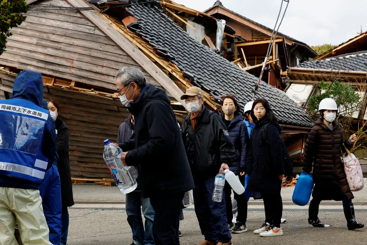 輪島市目前斷水，居民只能拿著容器排隊取水。路透社