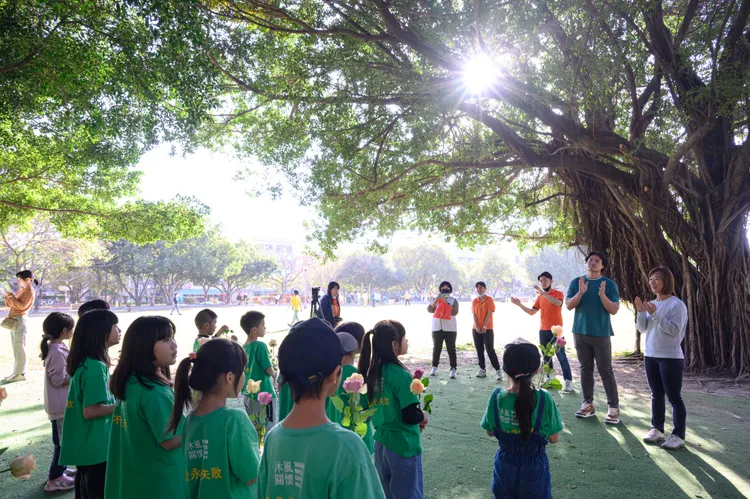 郭曉玲與張育成陪沐風學童課輔班的孩子打棒球。永齡基金會提供