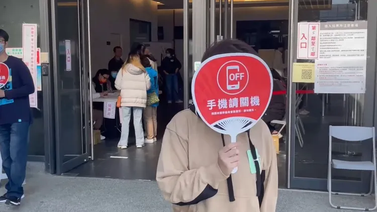 選務人員提醒民眾手機請關機。張沛森攝