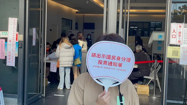 工作人員提醒民眾攜帶身分證和投票通知單。張沛森攝