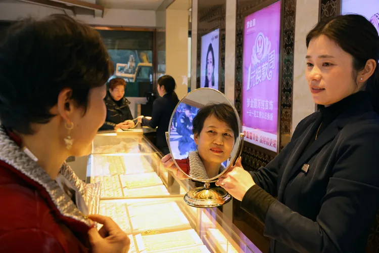 去年12月浙江湖州一家黃金店中，顧客挑選首飾。新華社
