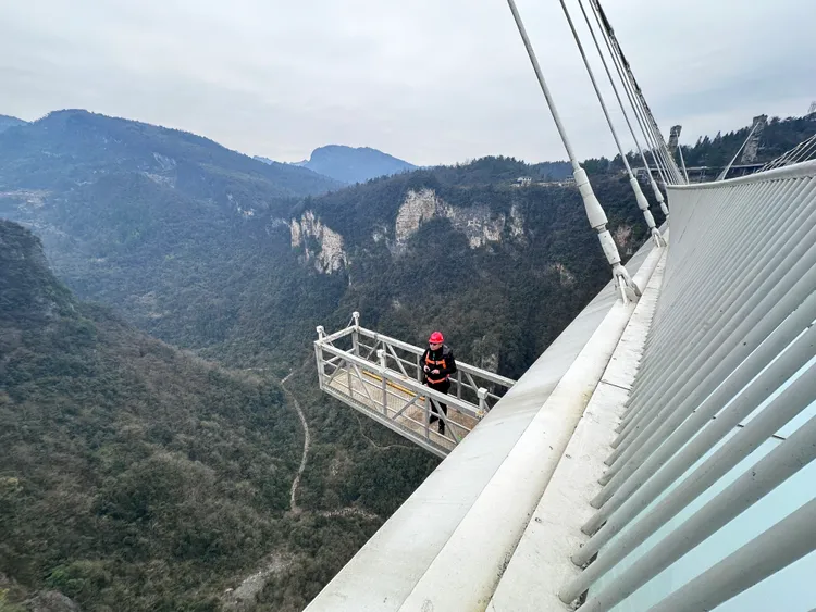 張家界大峽谷玻璃橋上，工作人員上月底作全面檢查，迎接春節遊客。新華社