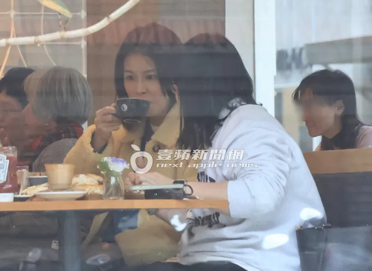 曾沛慈（左）喝著熱飲認真聆聽公事。特勤中心攝