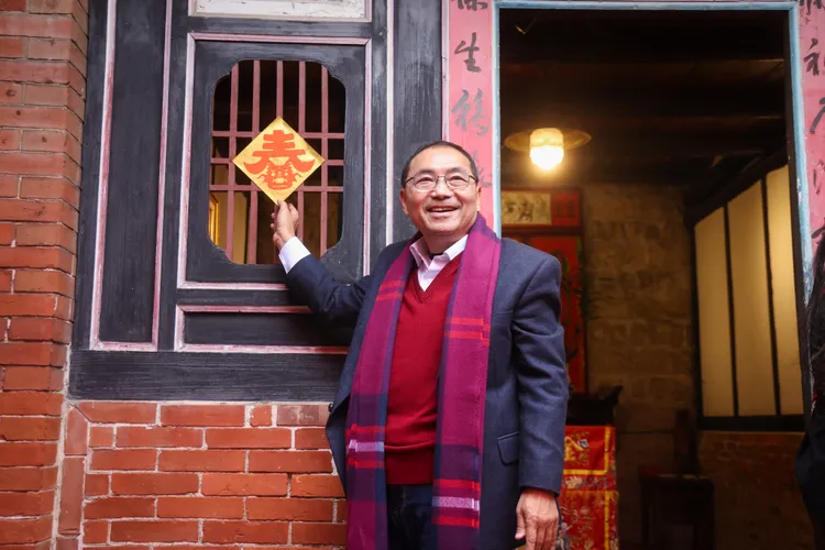 侯友宜親手將所剪的嶄新窗花貼上窗戶，象徵新年新氣象。新北市府提供