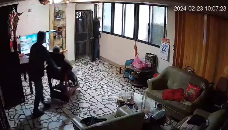 黑衣男(窗邊)PO出居家攝影機的畫面，表示他一開始是先開窗對樓下「抱歉，馬上好了」，但特拉斯駕駛頻按喇叭催促，計程車司機急忙推著他媽媽輪椅下樓差點翻覆，因此才找特斯拉女車主理論。翻攝自臉書「爆料公社二社」