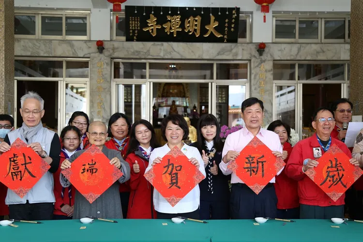 黃敏惠揮毫提「賀」，向國人拜年。嘉市府提供