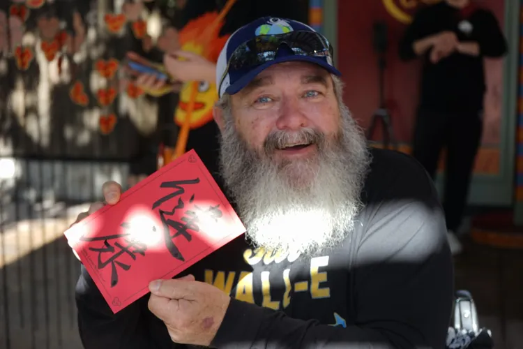 美國遊客開心展示中國書法家寫給他的新年祝福。新華社