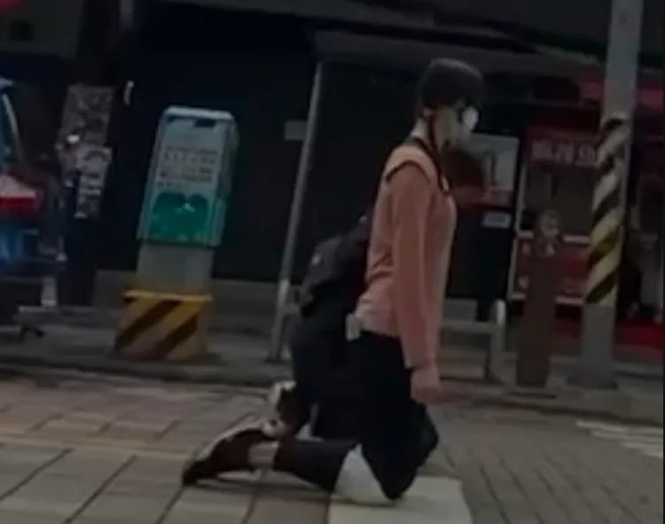 李女戴護膝向黃妻下跪道歉。黃妻提供