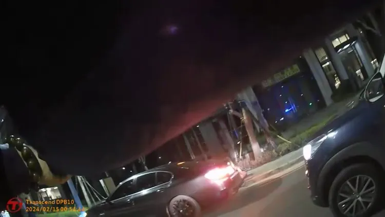 員警持槍對著黑色BMW轎車，看見嫌犯試圖衝撞，連開多槍制止。民眾提供