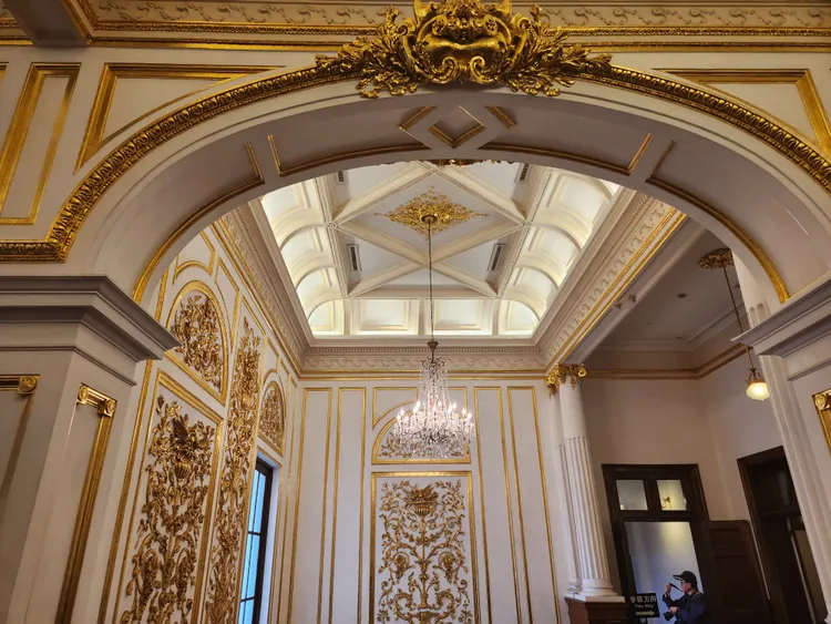 二樓牆面佈滿金箔，主梯上空懸掛百年水晶燈。施智齡攝