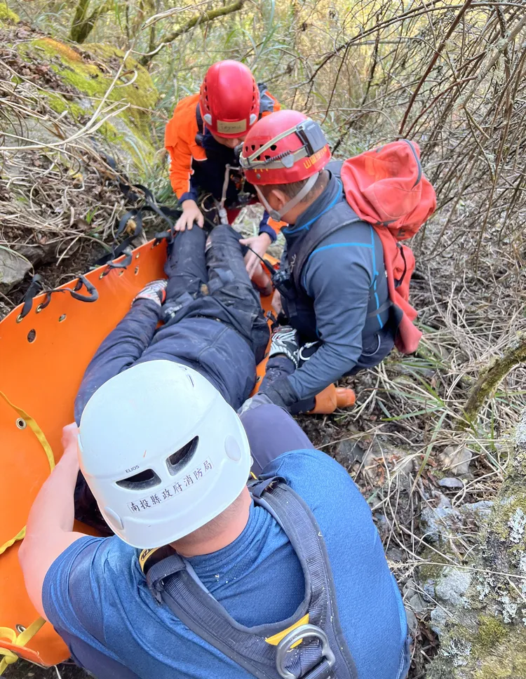 搜救人員將傷者包覆穩固後，自深谷拖拉至道路上。翻攝畫面