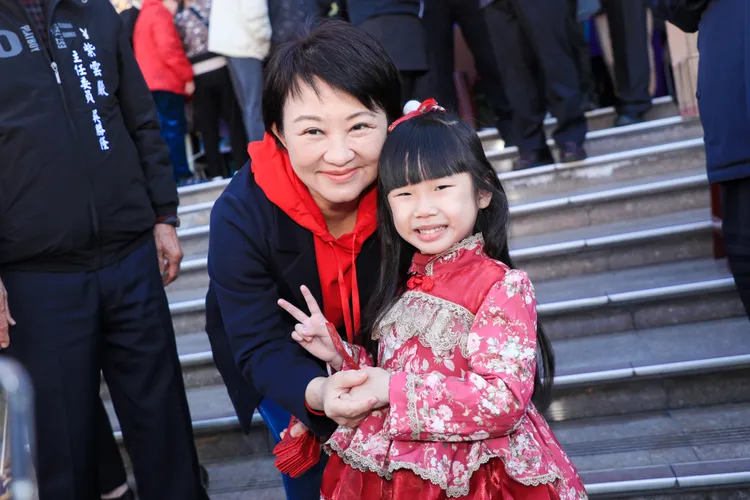 盧秀燕在清水紫雲巖發送小紅包，還與小粉絲合照。市府提供