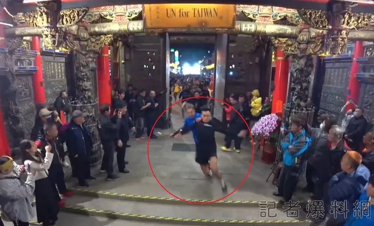 原本跑第一、二的黑衣與藍衣信眾，疑似藍衣男出手拉扯黑衣信眾，兩人最後相撞滑倒。翻攝自記者爆料網
