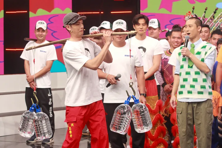 曹佑寧（左二）秀扁擔扛水。民視提供