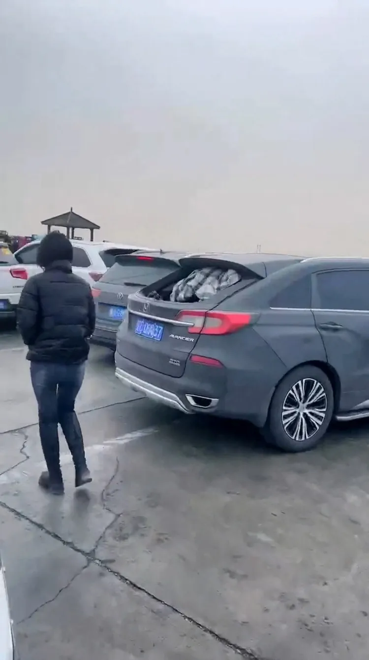 有車主拿起衣物等布料掛在被沙塵暴吹破的車窗上，抵擋零下嚴寒。路透社