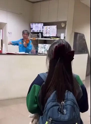 保全在小女童面前表演小提琴，當場演奏出日本卡通「龍貓」主題曲「豆豆龍」，讓女童驚呼連連！翻攝《爆廢1公社》社團