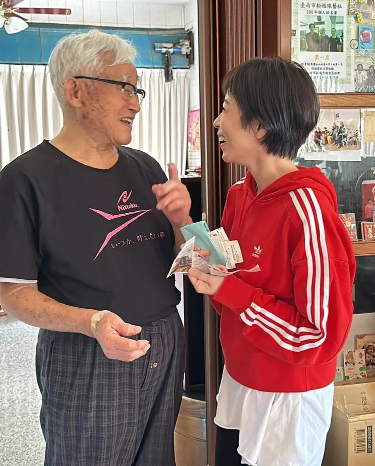 王瞳（右）到阿公家拜年，阿公拿出《愛的榮耀》新聞剪報拍照。民視提供