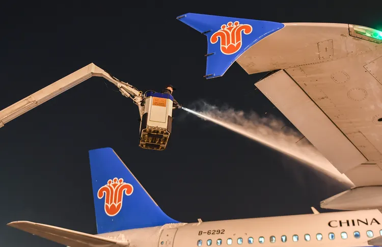 武漢天河國際機場工作人員，6日晚間為飛機除冰除雪。新華社