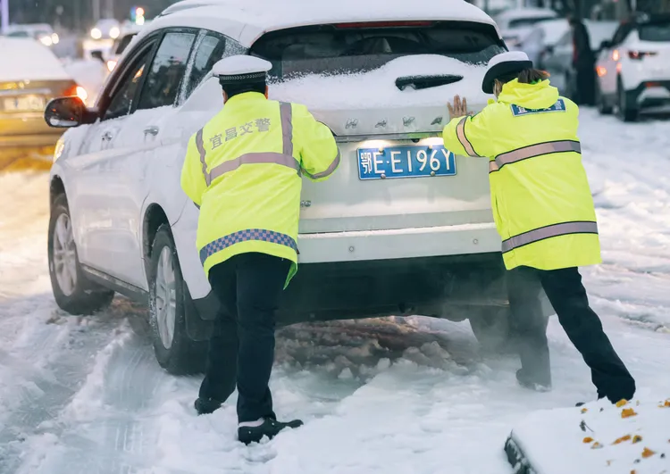 湖北省民警幫忙移動拋錨車輛。新華社