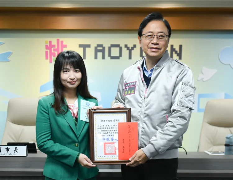 張善政表揚玉山商業銀行藝文分行助理專員張育瑄。桃園市府提供