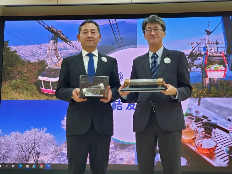 別府空中纜車社長吉原稔郎（左）與台北捷運公司遊憩休閒事業處長黃景南簽訂友好協定締結書，並交換雙方纜索，象徵彼此宛如鋼鐵般的友誼。北捷提供