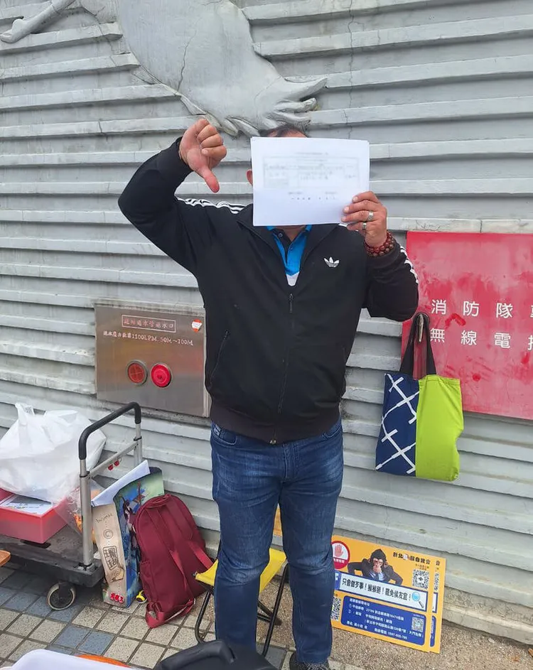 有民間團體發起罷免新北市長侯友宜活動，3日在蘆洲區舉辦快閃連署活動，號召民眾響應，有人寫完連署書後比出倒讚表達立場。（主辦單位提供）中央社