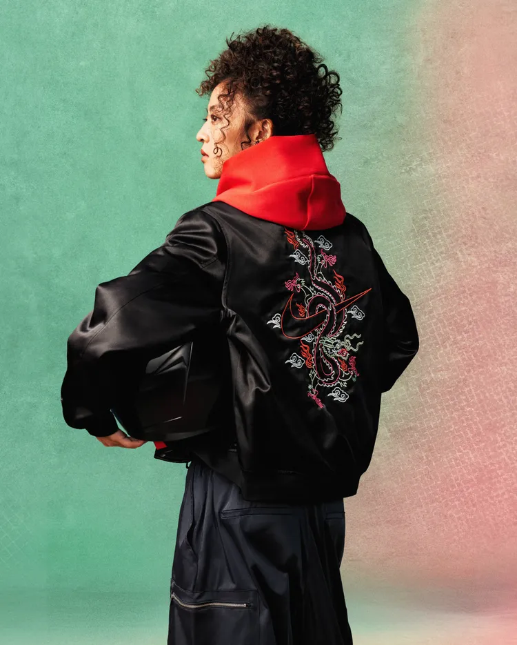 女子黑色夾克採用光滑材質搭配復古霓虹色彩龍紋覆面。品牌提供