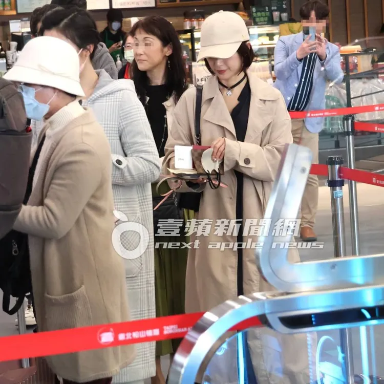 酒井法子掏出LV護照套，排隊檢查機票和護照。特勤中心攝