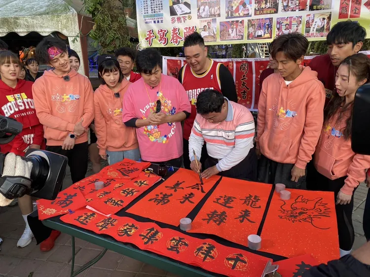 藝人們看大師揮毫寫春聯。民視提供