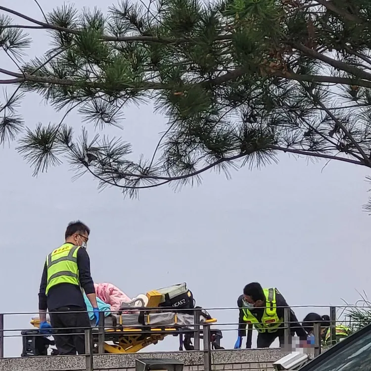 邱女墜落至百貨公司與分局大樓中間地下停車場車道旁。民眾提供