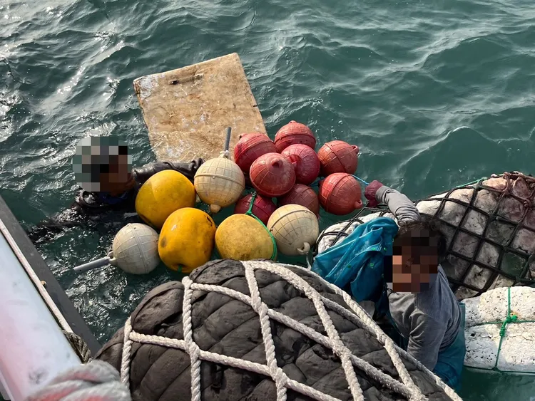 船長與另名船員急忙爬回船上。布袋海巡隊提供