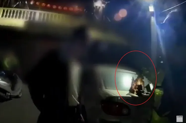 廖男(左)對穿著螢光背心的警員坦承，他是拿神像來歸還的。翻攝自記者爆料網